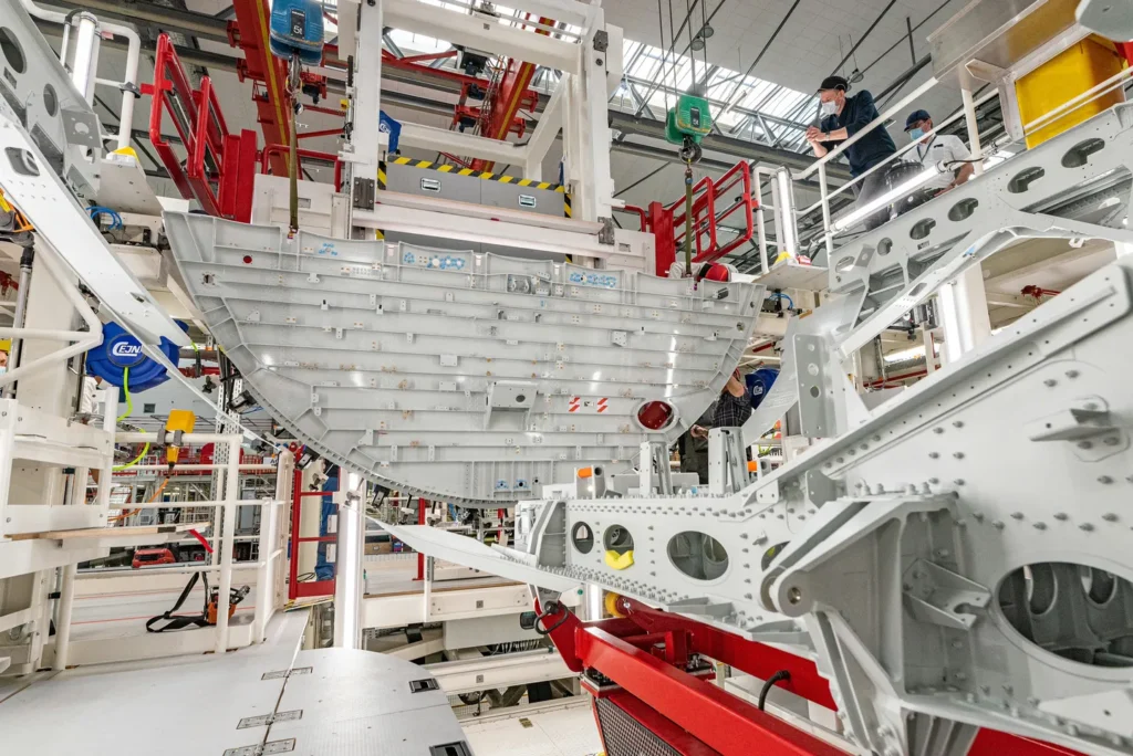 a large white metal structure in a factory