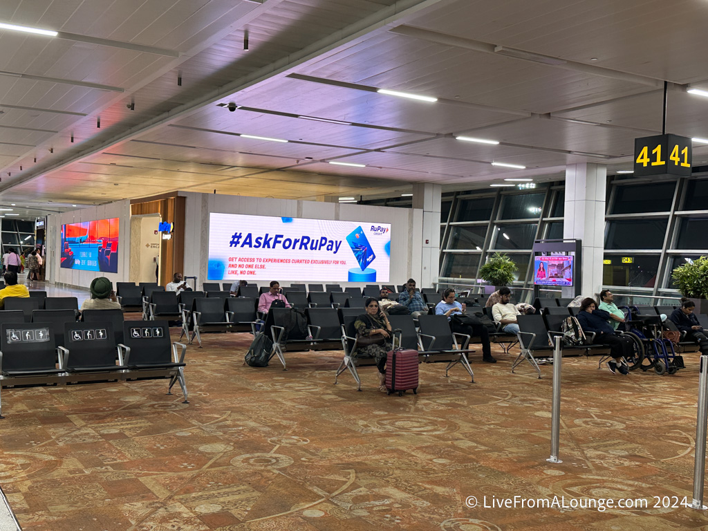 people sitting in chairs in an airport