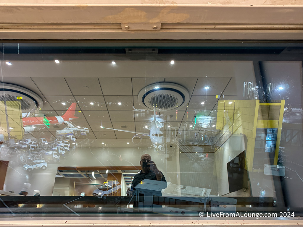 a man looking at a plane through a window