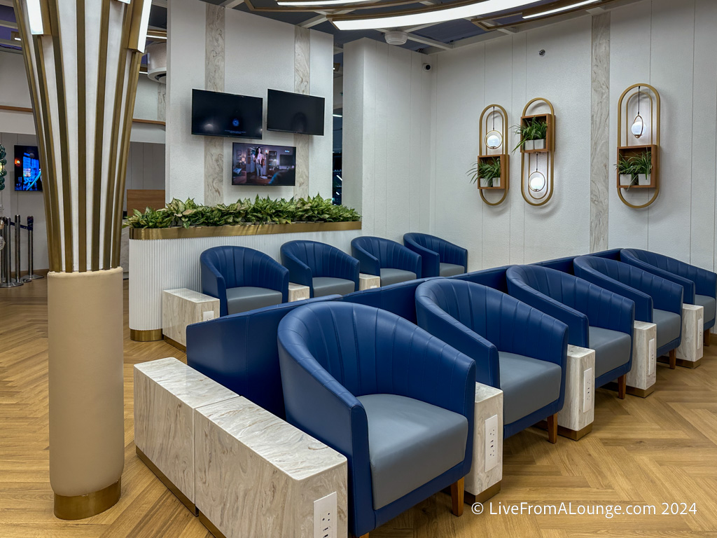 a room with blue chairs and a tv on the wall