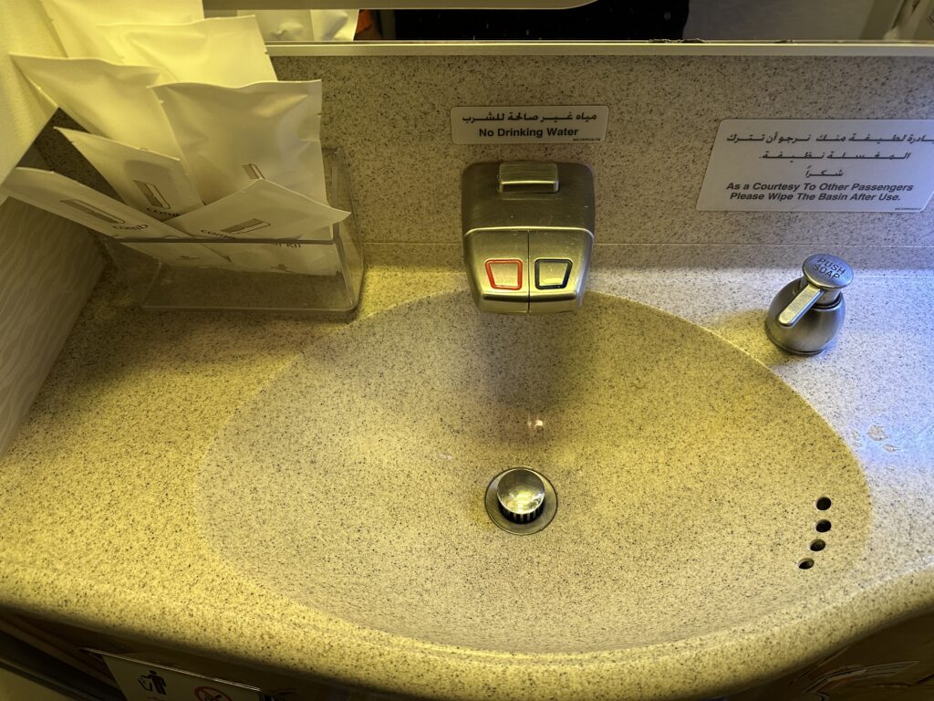 a sink with a button and a faucet