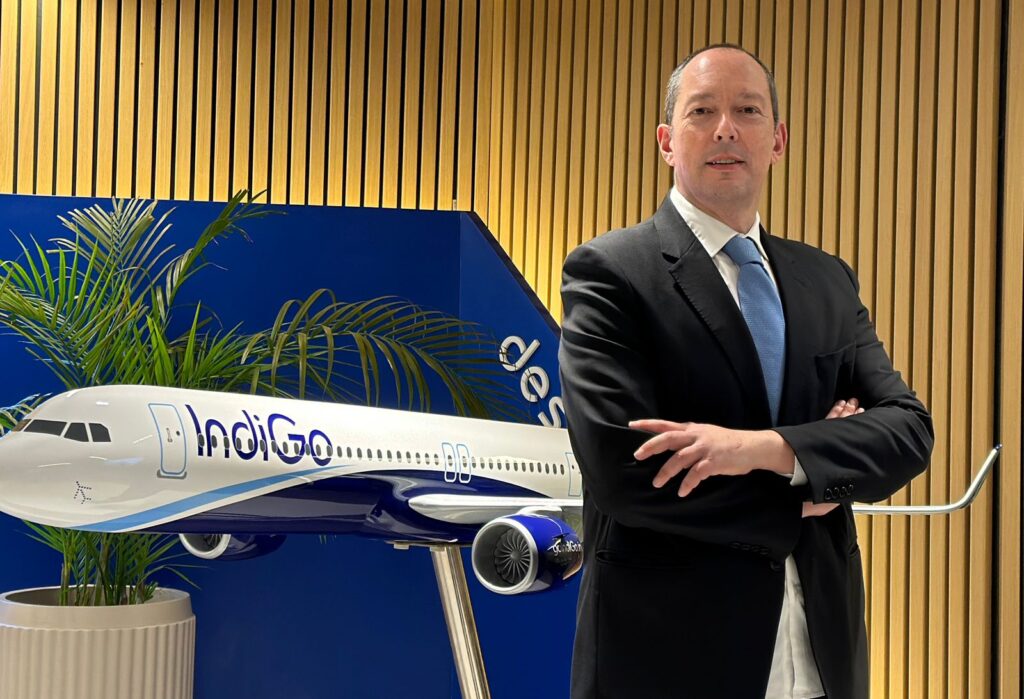 a man in a suit standing in front of a model airplane