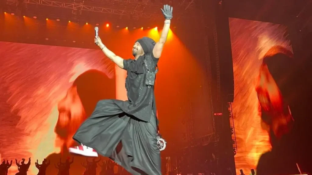 a man in black clothes jumping in the air with his arms up