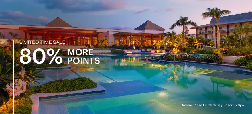 a pool with palm trees and a building