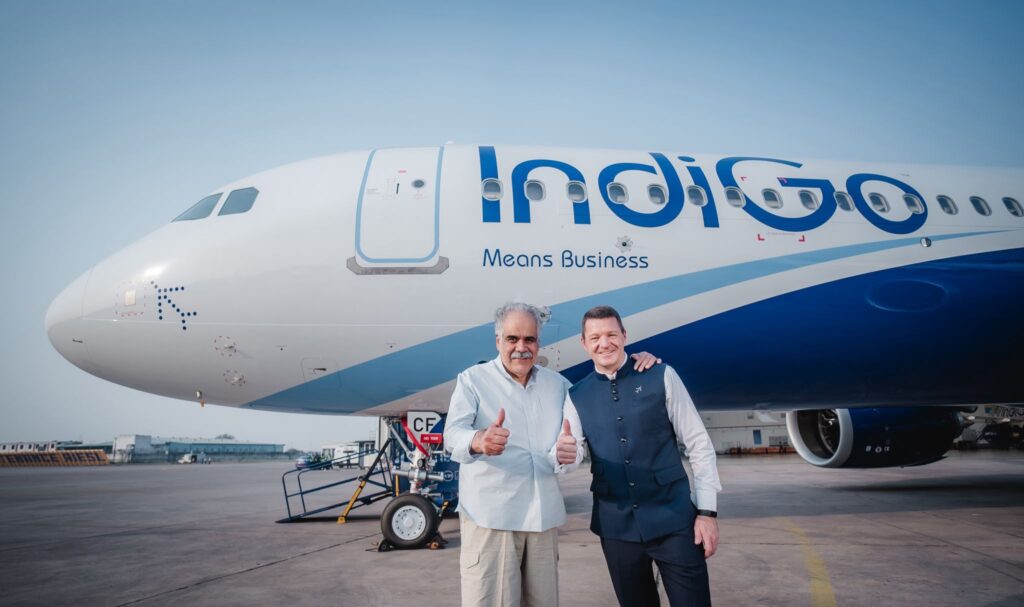 two men standing in front of an airplane