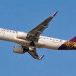 a white and purple airplane flying in the sky