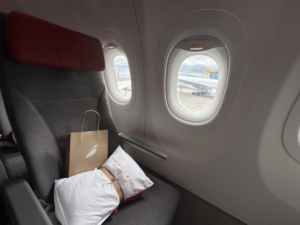 a seat with a bag on it and windows in the background