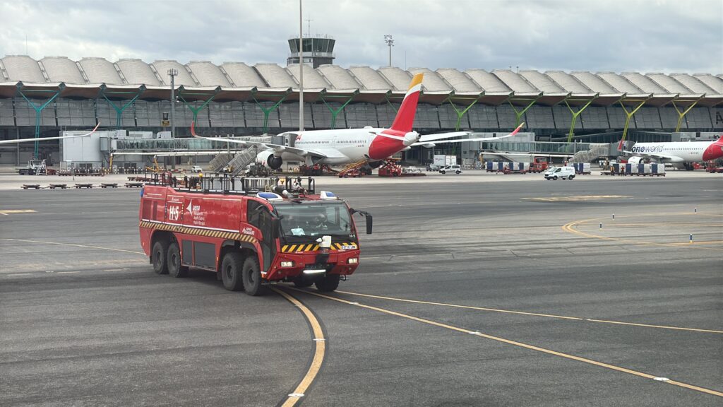 a red truck and a plane in a runway