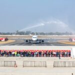 a group of people standing in front of a jet plane