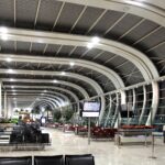 an airport terminal with chairs and tables