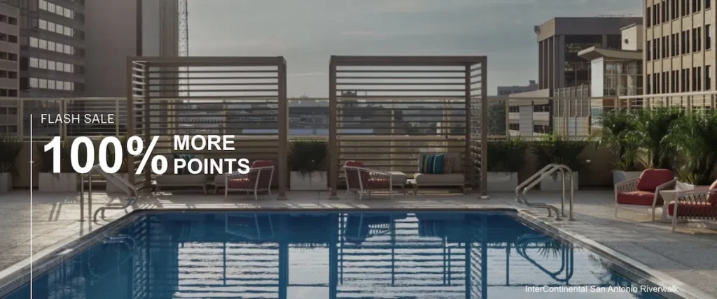 The image shows a rooftop swimming pool surrounded by lounge chairs and cabanas. The pool area is on a high-rise building with a cityscape in the background. There is text on the image that reads "Flash Sale 100% More Points." The location is identified as the InterContinental San Antonio Riverwalk.
