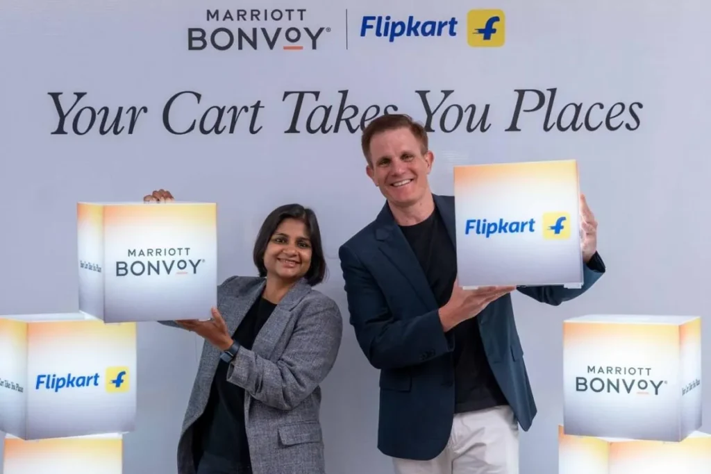 Two people are smiling and holding illuminated boxes with the logos of Marriott Bonvoy and Flipkart. The background features the text "Your Cart Takes You Places" along with the Marriott Bonvoy and Flipkart logos.