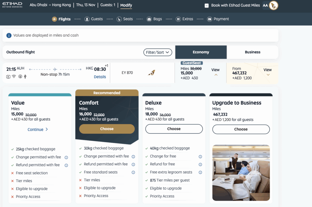 The image is a screenshot of a flight booking page from Etihad Airways. It shows options for an outbound flight from Abu Dhabi to Hong Kong on Thursday, November 13. The flight details include a departure time of 21:15 and an arrival time of 08:30, with a non-stop duration of 7 hours and 15 minutes. There are different fare options available: Value, Comfort, Deluxe, and Upgrade to Business, each with different mileage costs and additional fees in AED. The Comfort option is marked as recommended. Each option lists benefits such as checked baggage allowance, change and refund policies, seat selection, and other perks. The Upgrade to Business option includes an image of passengers seated in a business class cabin.