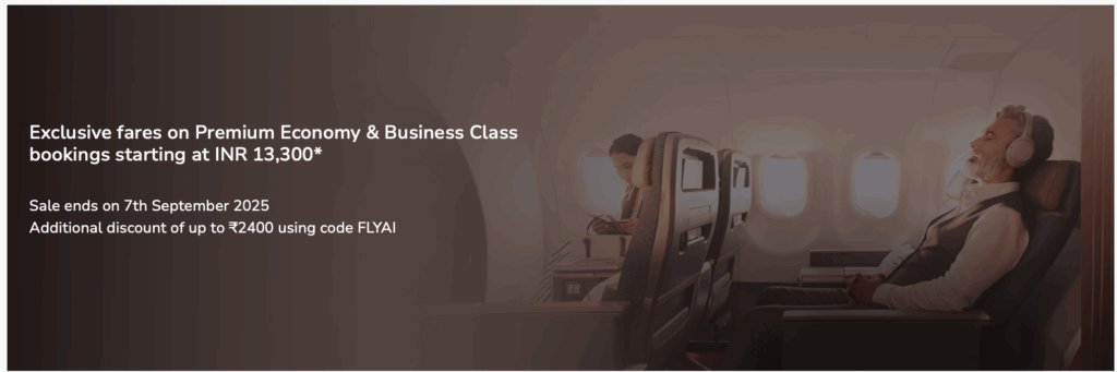 The image shows an airplane interior with two passengers seated in a premium cabin. One person is relaxing with headphones on, while the other is reading a book. The left side of the image contains text advertising exclusive fares on Premium Economy and Business Class bookings starting at INR 13,300, with a sale ending on 7th September 2025. An additional discount of up to ₹2400 is available using the code FLYAI.