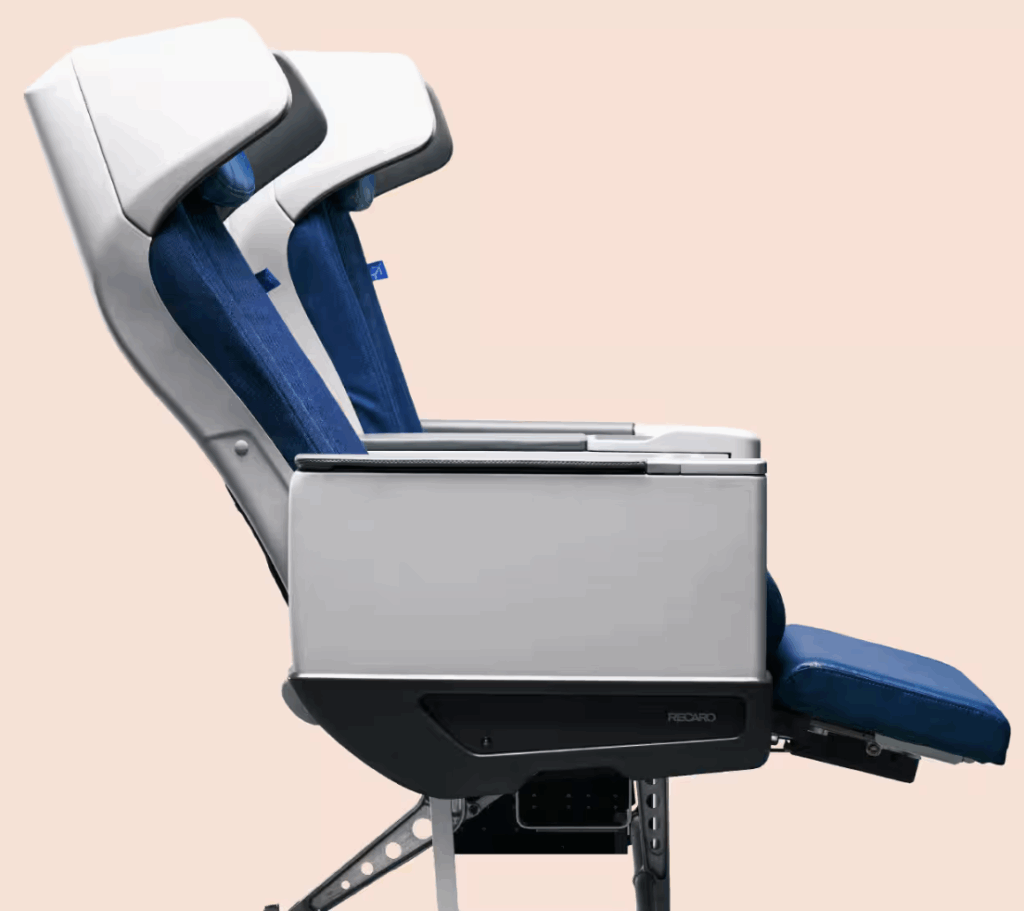 The image shows two modern airplane seats in a side view. The seats have a sleek design with white and blue upholstery. The seat in the foreground has a leg rest extended, and both seats have a headrest. The background is a plain light peach color.