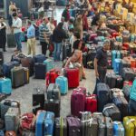 a group of people standing in a room with luggage