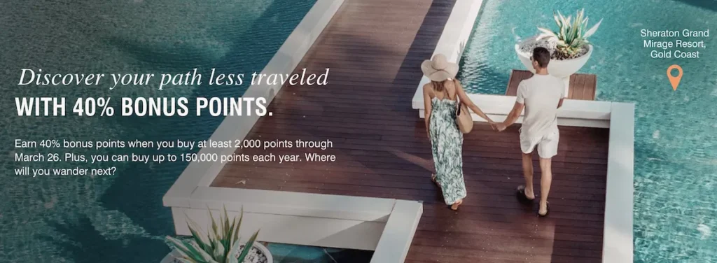 A couple is walking hand in hand on a wooden boardwalk surrounded by water, with tropical plants nearby. The woman is wearing a sun hat and a long dress, while the man is in a white shirt and shorts. Text on the image promotes a 40% bonus points offer and mentions the Sheraton Grand Mirage Resort, Gold Coast.