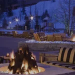 The image shows an outdoor seating area at Park Hyatt Beaver Creek Resort and Spa in Colorado. There are striped cushioned chairs and sofas arranged around a fire pit. In the background, there is snow on the ground, trees, and a ski lift. The text on the image reads: "Buy 3,000+ points and save 20%. Reach your next getaway faster. Save 20% when you buy Bonus Points through April 7, 2026."