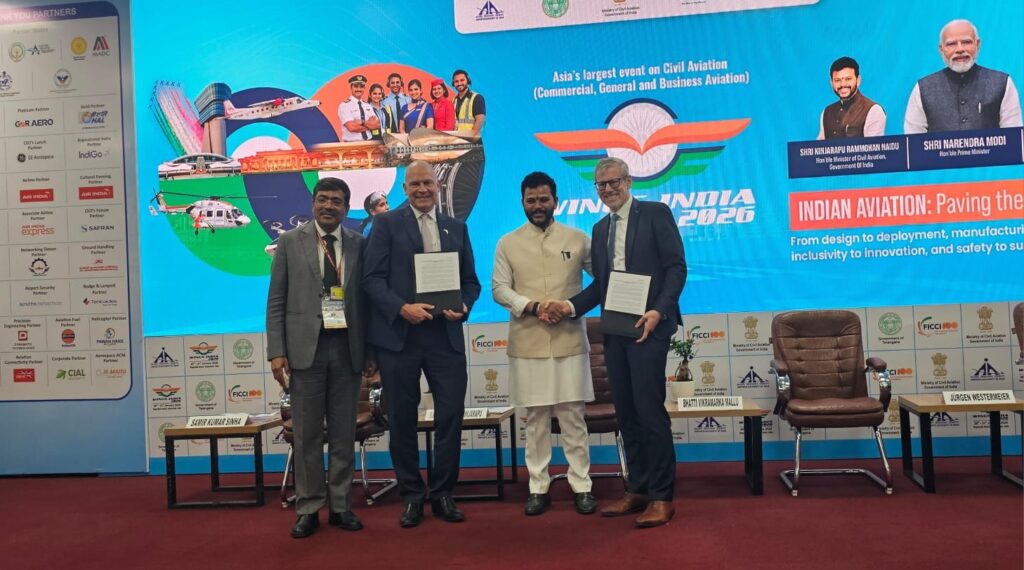 The image shows four men standing on a stage at an aviation event. They are dressed in formal attire, with two of them holding documents. Behind them is a large screen displaying graphics related to aviation, including images of aircraft, an airport terminal, and aviation professionals. The screen also features text about the event, highlighting it as Asia's largest civil aviation event. There are logos and names of partners and sponsors on the side panels.
