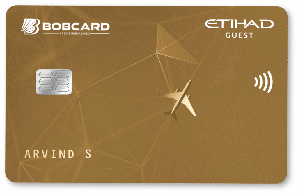 This image shows a credit card with a gold background. The card features the "BOBCARD" logo and the words "CREDIT REIMAGINED" at the top left. The "ETIHAD GUEST" logo is at the top right. There is a chip on the left side and a contactless payment symbol on the right. An airplane graphic is in the center, and the name "ARVIND S" is printed at the bottom left.