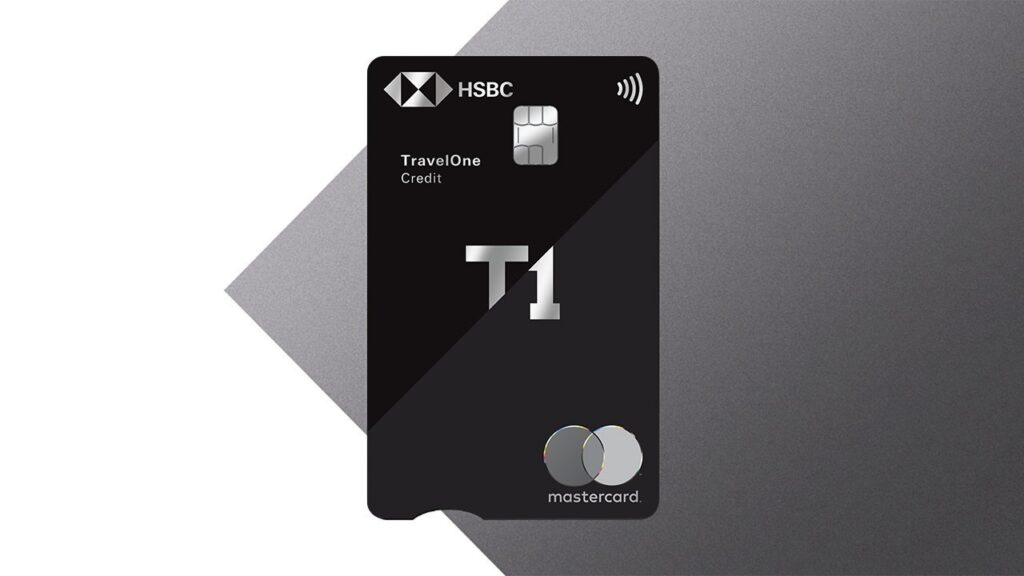 The image shows a black HSBC TravelOne credit card with a chip and contactless symbol. The card features the text "T1" prominently in the center. The Mastercard logo is at the bottom right corner. The background is a gradient of dark gray shades.