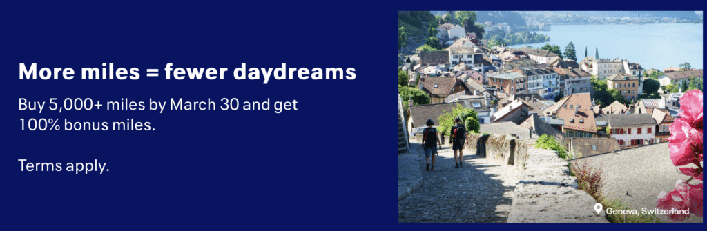 The image is a promotional advertisement. On the left side, there is text on a dark blue background that reads: "More miles = fewer daydreams. Buy 5,000+ miles by March 30 and get 100% bonus miles. Terms apply." On the right side, there is a scenic photograph of Geneva, Switzerland, showing a view of a town with rooftops, a lake in the background, and two people walking down a cobblestone path. Pink flowers are visible in the foreground.