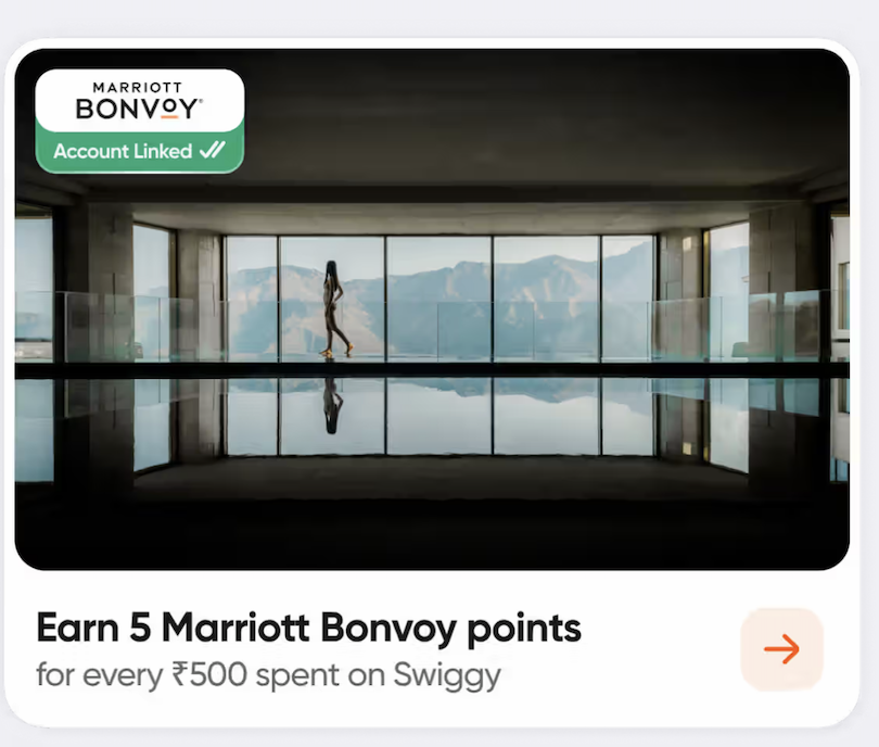 The image shows a person walking alongside an indoor pool with large windows in the background, offering a view of mountains. The top left corner has a Marriott Bonvoy logo with "Account Linked" text. Below the image, there's text stating, "Earn 5 Marriott Bonvoy points for every ₹500 spent on Swiggy," with an arrow icon on the right.