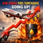 The image features an Air India airplane flying upwards with a red arrow pointing in the same direction, symbolizing an increase. Below, there is a large oil barrel surrounded by flames, with a yellow oil drop symbol on it. Dollar signs are floating around, indicating rising costs. A fuel pump nozzle is dripping fuel in the foreground. The text at the top reads, "Air India Fuel Surcharge Going Up!"