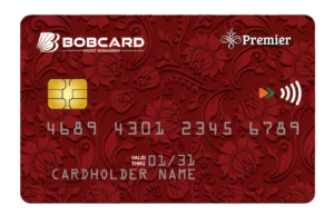 The image shows a red credit card with an ornate floral pattern. The card features a chip on the left side and the numbers "4689 4301 2345 6789" in the center. The card is branded "BOBCARD" with the tagline "Credit Reimagined" and "Premier" on the top right. It also has a contactless payment symbol. The cardholder's name is displayed as "CARDHOLDER NAME," and the card is valid through "01/31."
